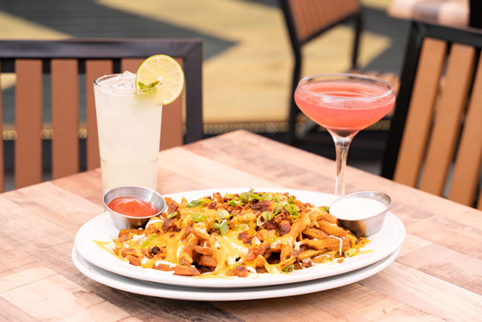 Fries Smothered in Cheese with Two Cocktails